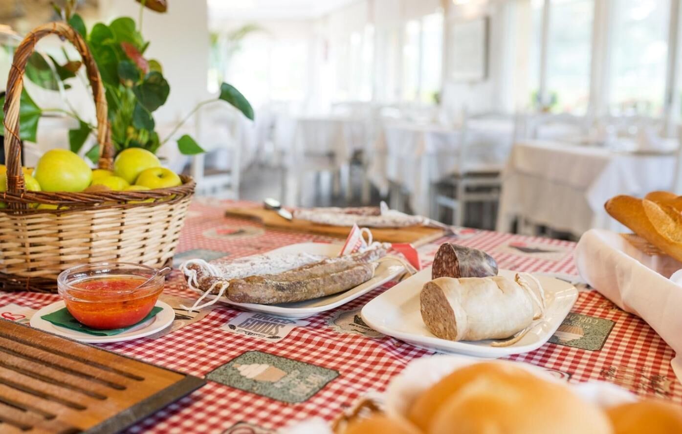 A table with food items including bread, a bowl of soup, and a basket of apples.