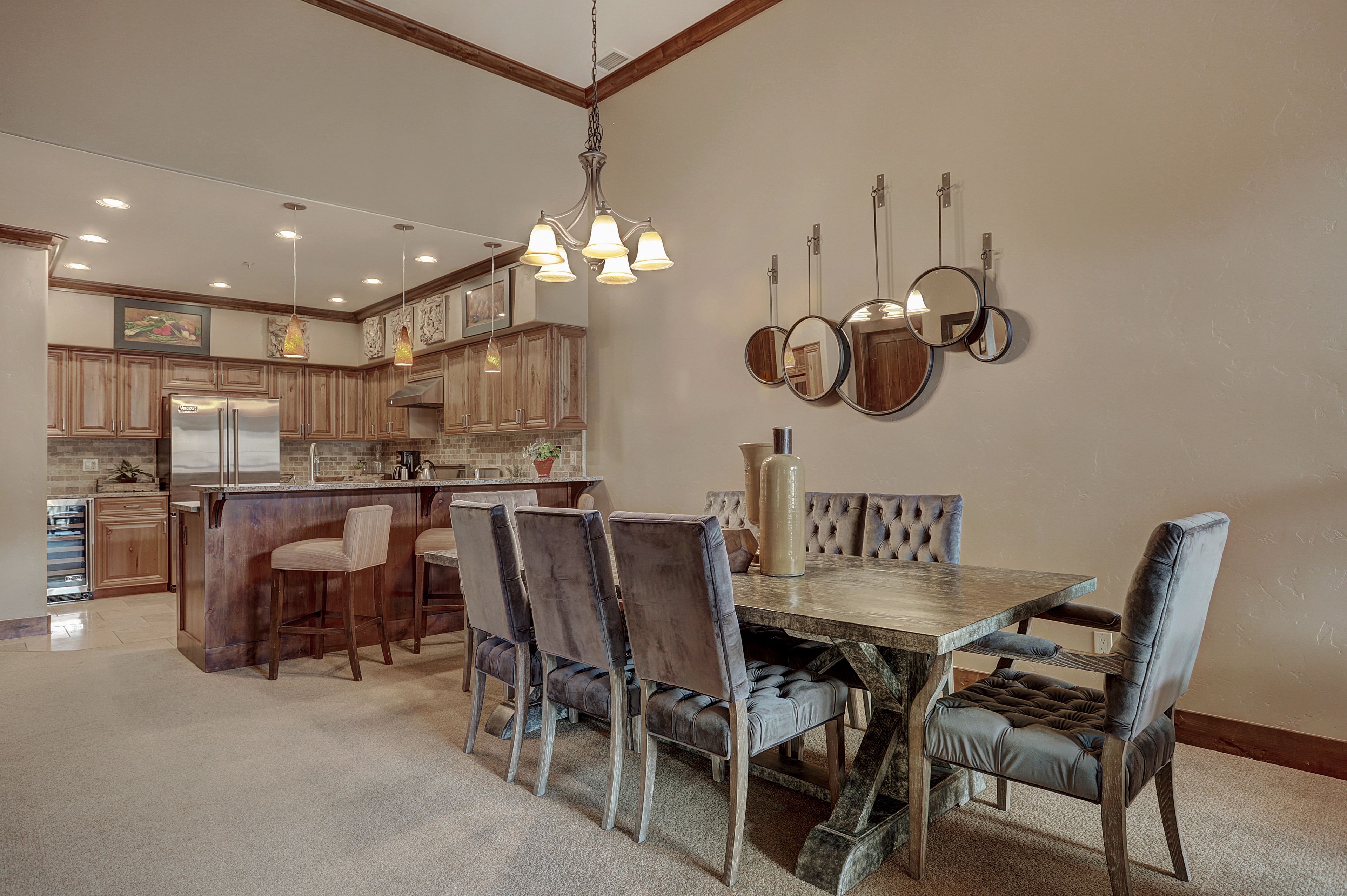 Una cocina amplia con una isla central, armarios de madera y un refrigerador de acero inoxidable.