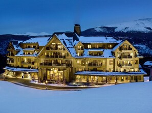 A large, multi-story hotel with a symmetrical facade, multiple balconies, and a snow-covered landscape in the background. - Crystal Peak Lodge, A Vail Resorts Property (Breckenridge)