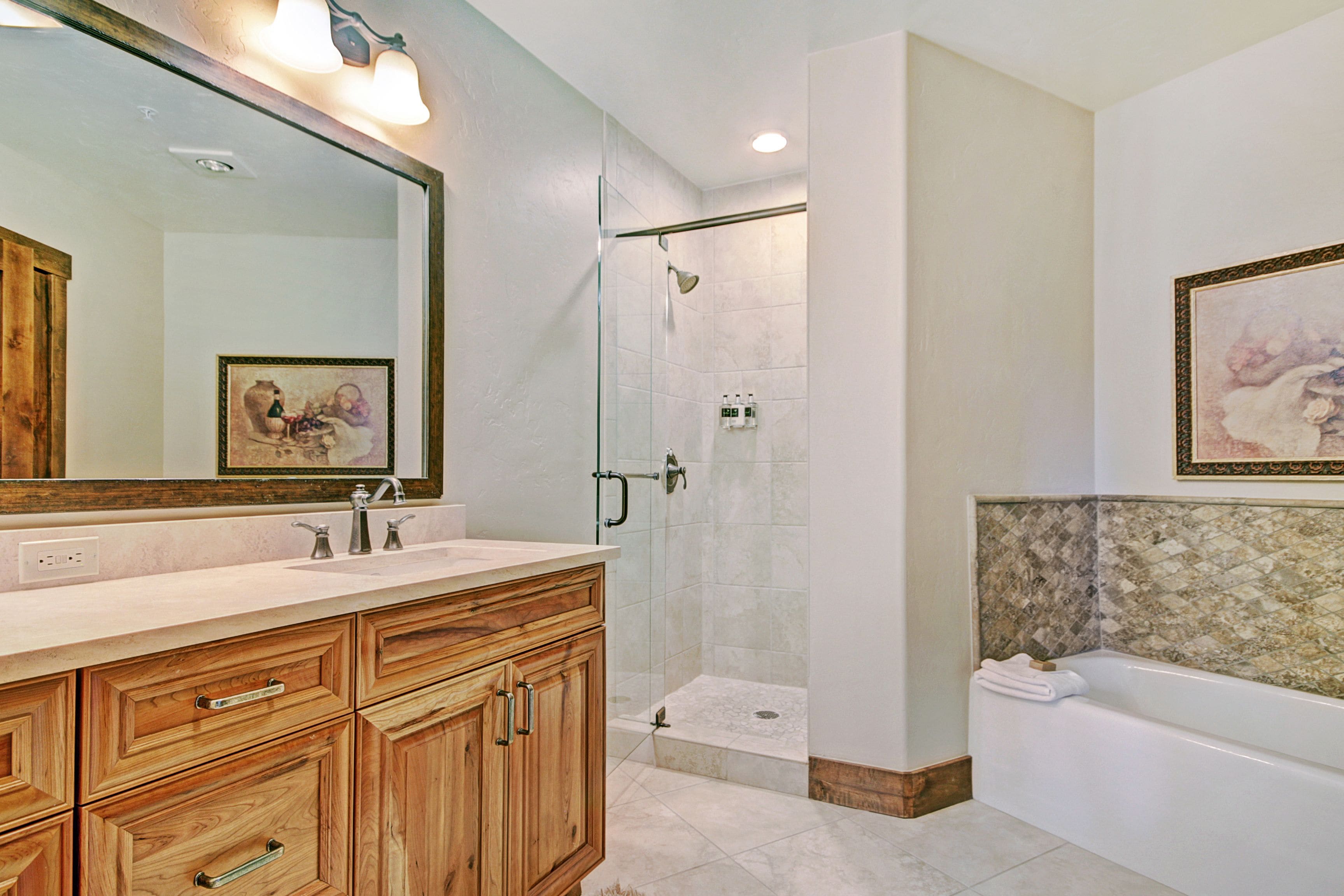 A modern bathroom with a glass-enclosed shower, a double sink vanity, and a large mirror.