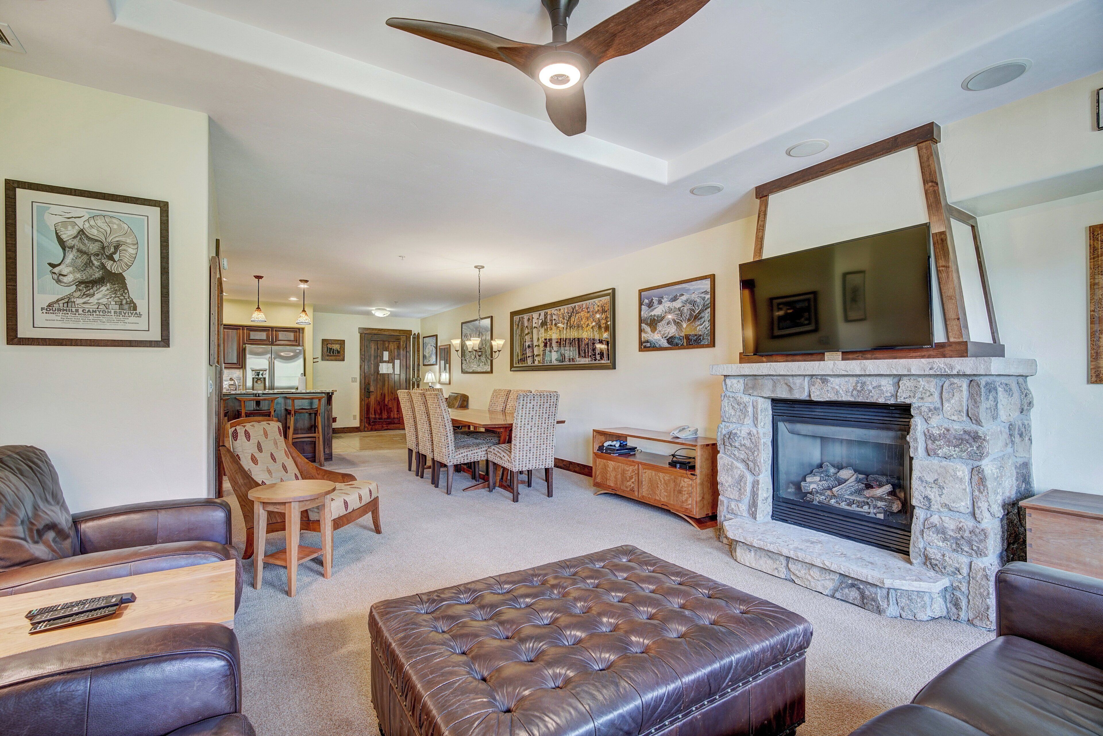 Amplia sala de estar con chimenea, muebles de cuero y un comedor.