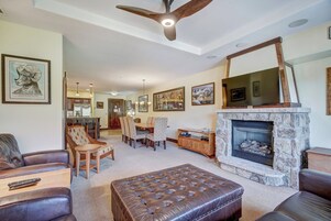 Amplia sala de estar con chimenea, muebles de cuero y un comedor.