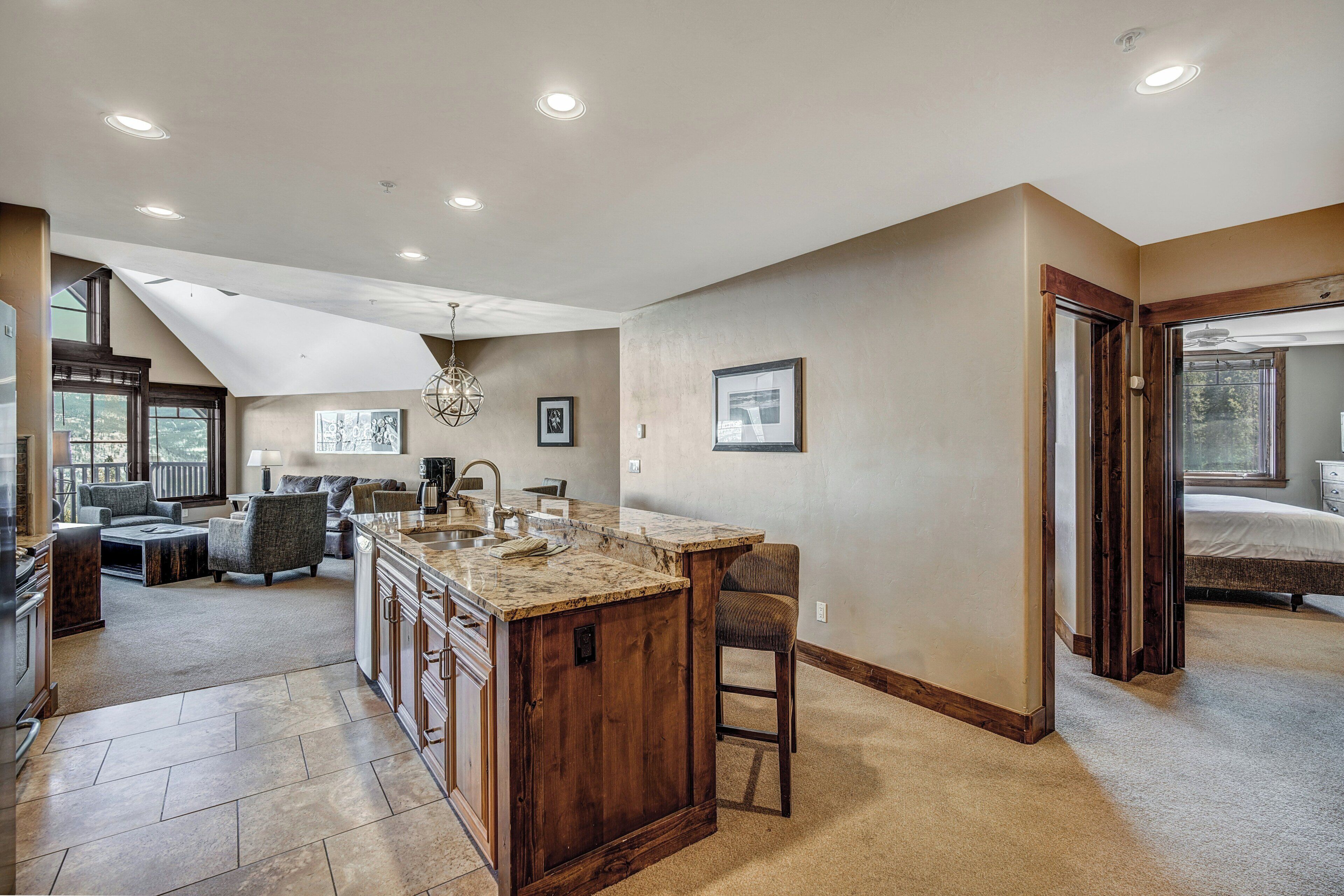 A spacious kitchen with a large island, a dining area, and a bedroom with a large window.