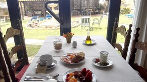 Een ontbijttafel met diverse etenswaren, waaronder fruit, brood en een drankje.