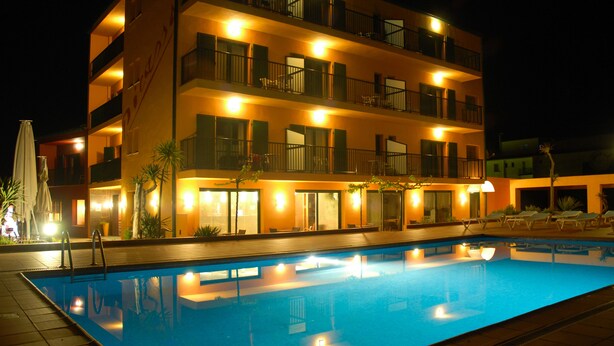 Un hôtel à plusieurs étages doté d’une piscine, de balcons et d’espaces de détente en plein air.