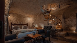 Une pièce confortable avec un lit, une chaise, une petite table et un escalier en colimaçon.