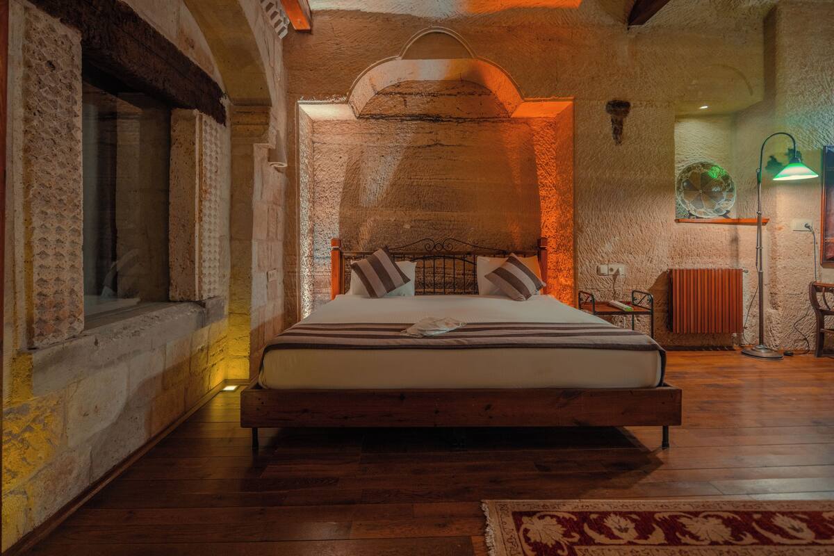 Un dormitorio con cama de madera, paredes de piedra y ambiente rústico.