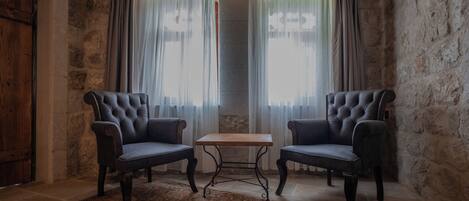 A room with two dark leather armchairs, a small wooden table, and a patterned carpet.