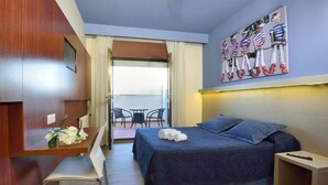 A hotel room with a bed, a desk with a chair, a small table with flowers, and a painting on the wall. - Nuevo Norat Sanxenxo (Sanxenxo)
