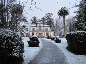 A snow-covered pathway leading to a two-story building with a balcony. - Hotel Quinta Duro (Gijon)