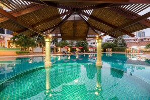 A swimming pool with a tiled floor and a wooden canopy overhead. - Mountain Beach Resort (Pattaya)