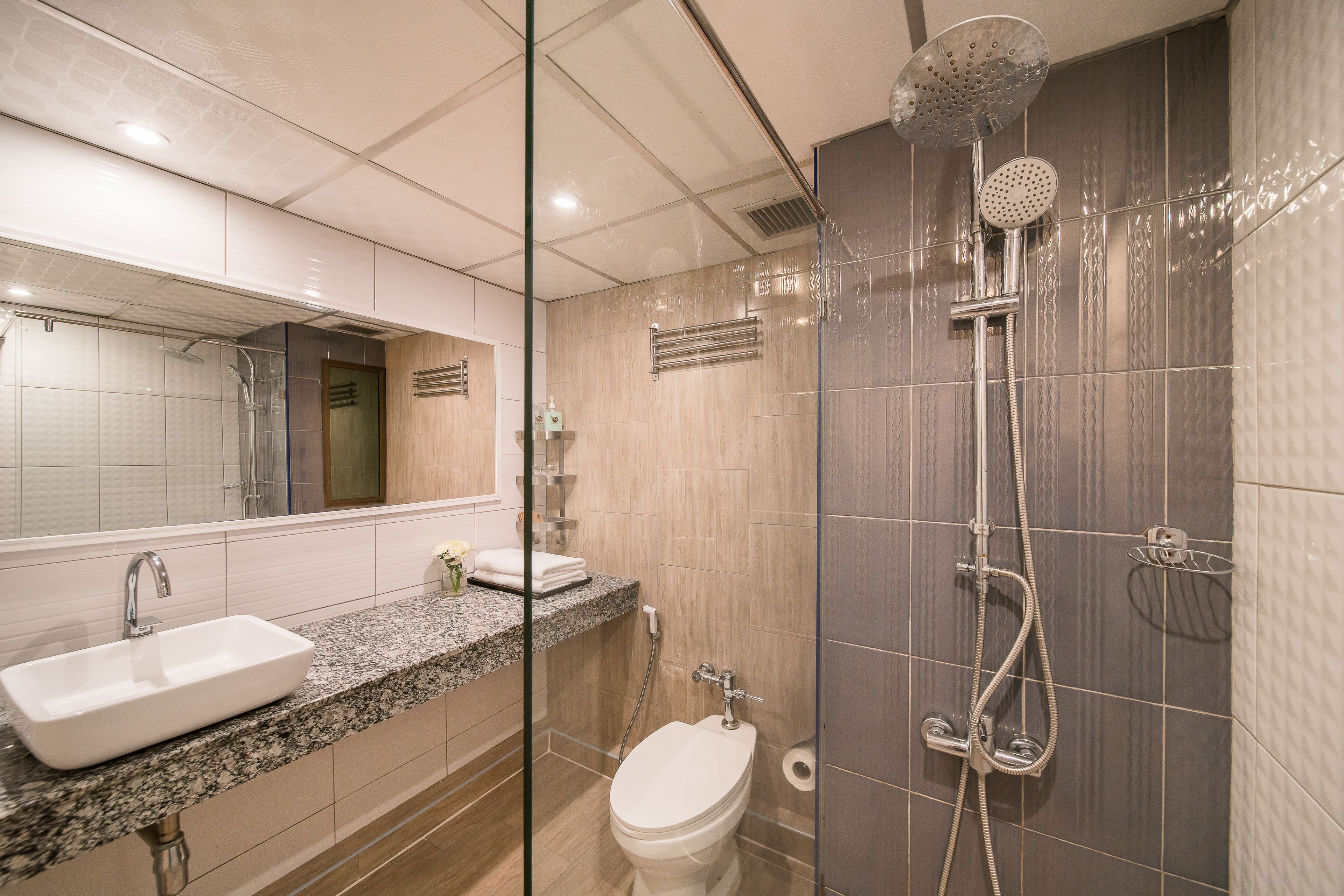 A modern bathroom with a sink, toilet, and shower.