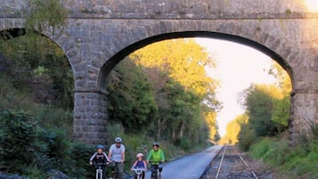 A stone bridge over railway tracks with cyclists.