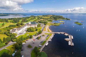 An aerial view of a coastal property with a large building, a marina with boats, and a parking lot. - Hodson Bay Hotel (Athlone)