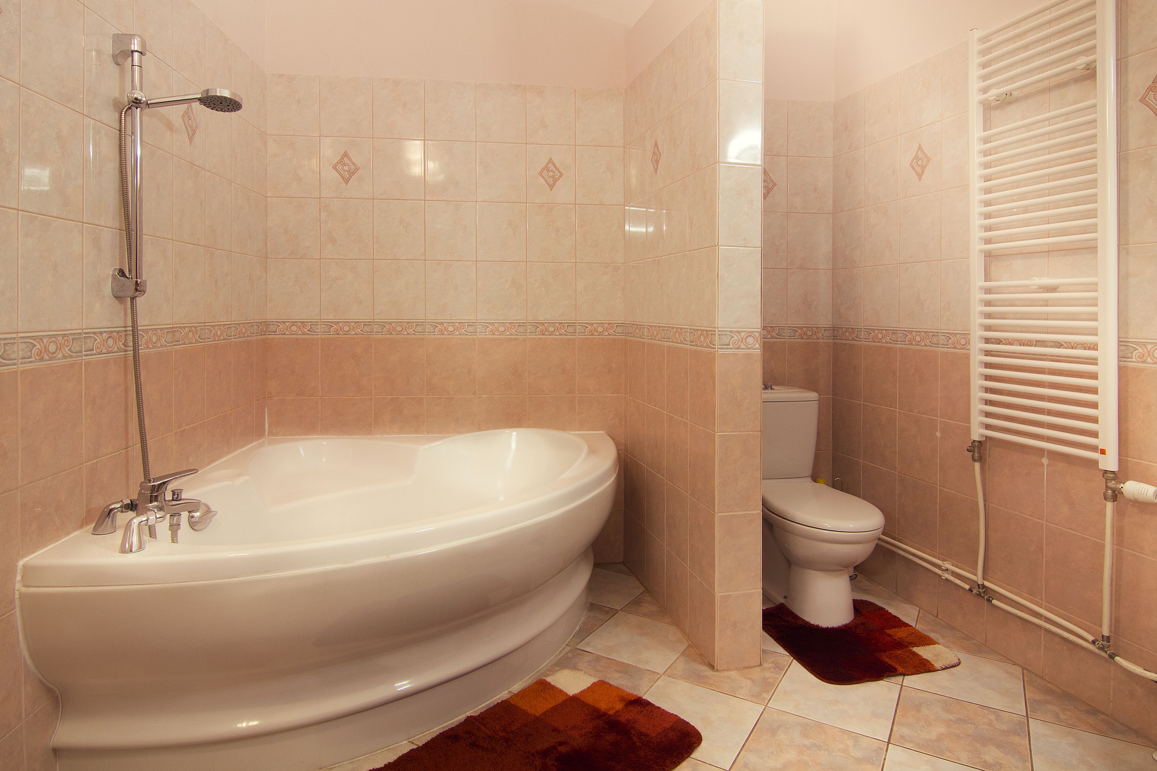 A bathroom with a freestanding bathtub, a toilet, and a towel rack.
