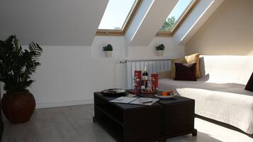 A modern living room with a sofa, a coffee table, and two skylights.