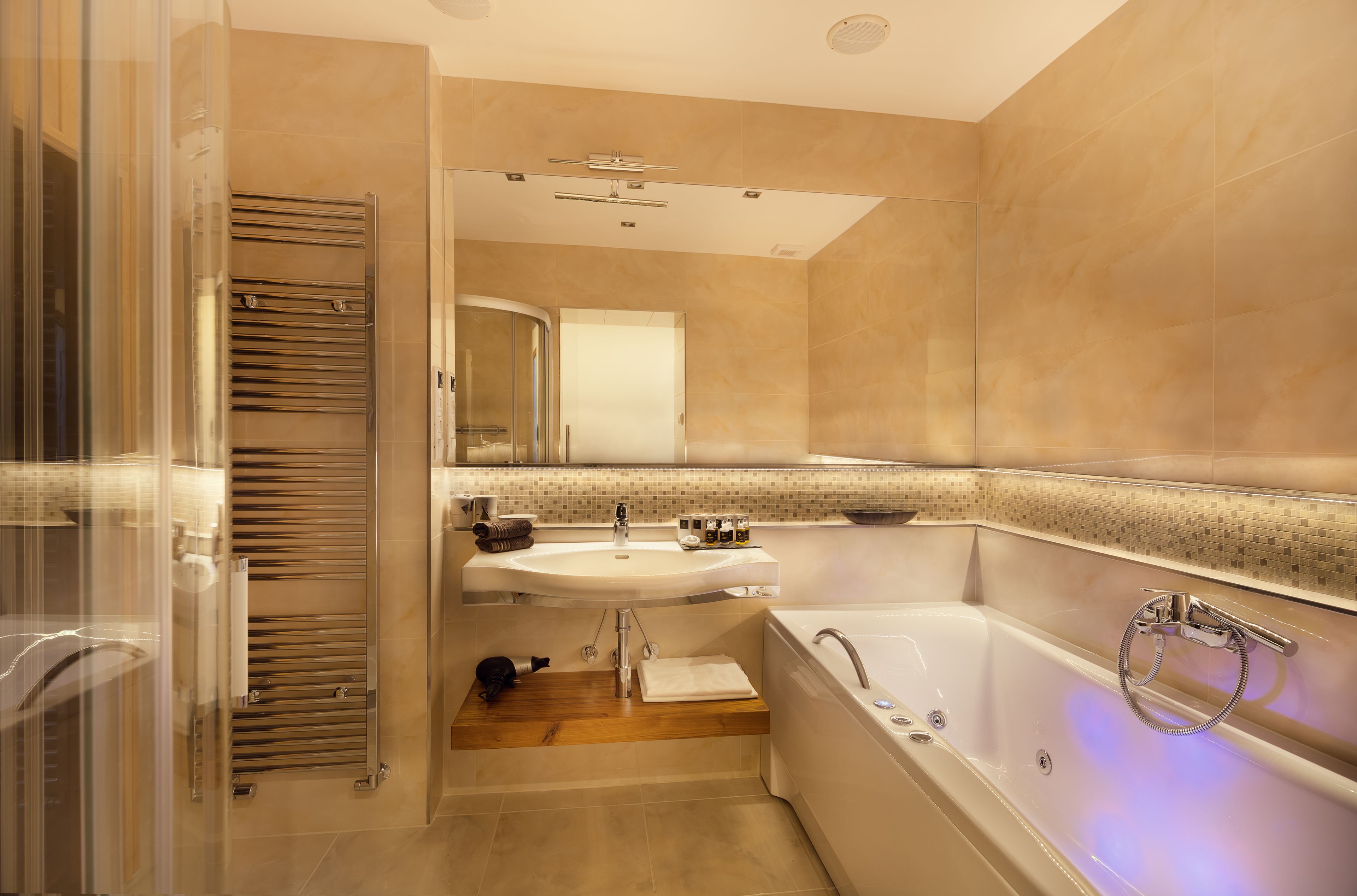 A modern bathroom with a glass shower enclosure, a sink, and a bathtub.