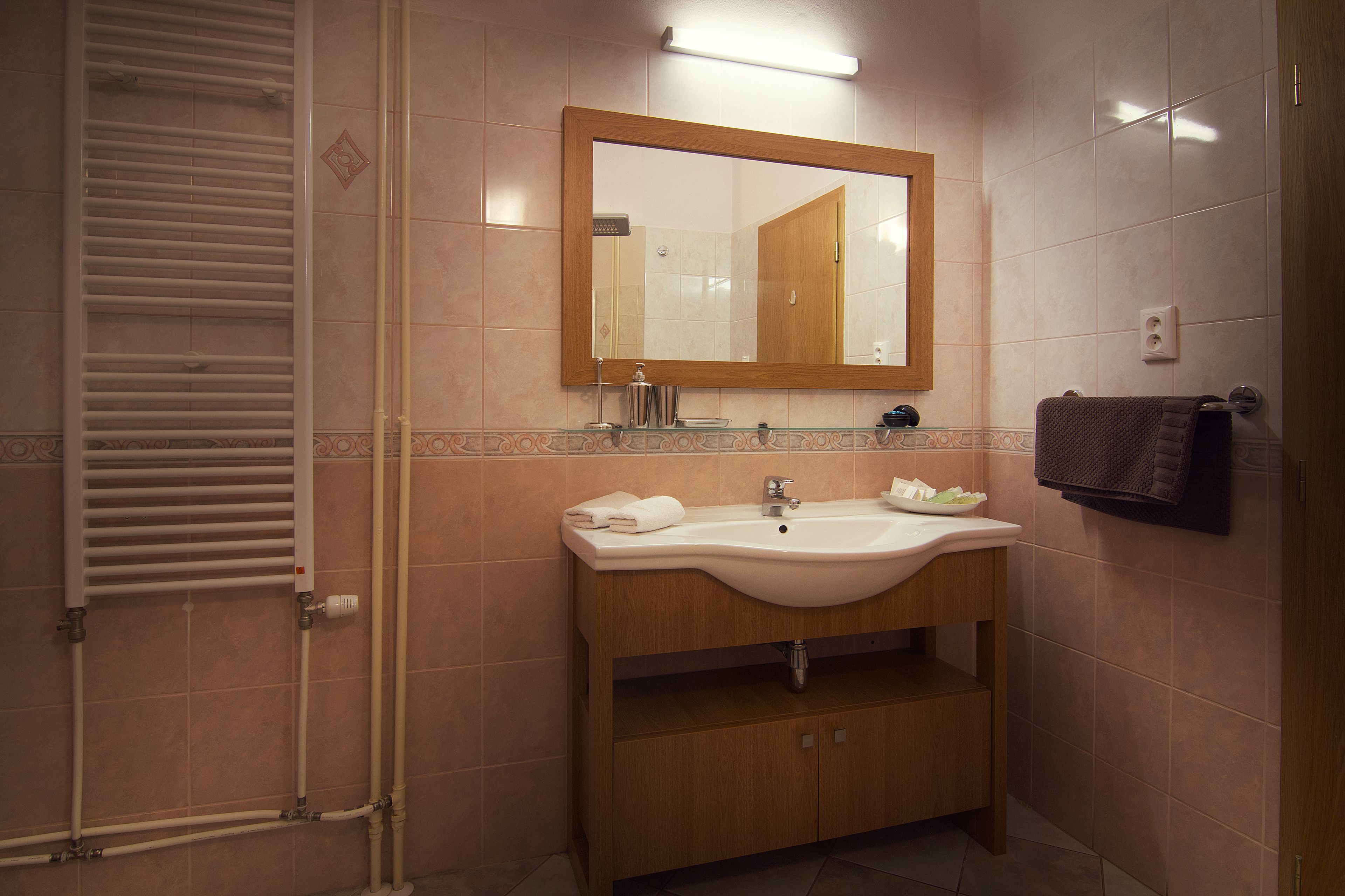A bathroom with a sink, mirror, towel rack, and a towel hanging on the wall.