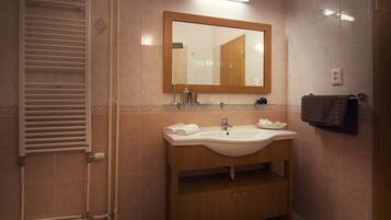A bathroom with a sink, mirror, towel rack, and a towel hanging on the wall.