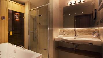 Een moderne badkamer met een douche in een glazen cabine, een ruim bad en een wastafel met spiegel.