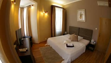 Een slaapkamer met een bed, nachtkastjes, een televisie en gordijnen.