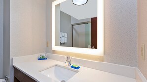 A bathroom with a white sink, a mirror, and a towel rack.