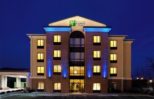 Un hotel Holiday Inn Express con fachada de ladrillo, múltiples ventanas y una entrada despejada.