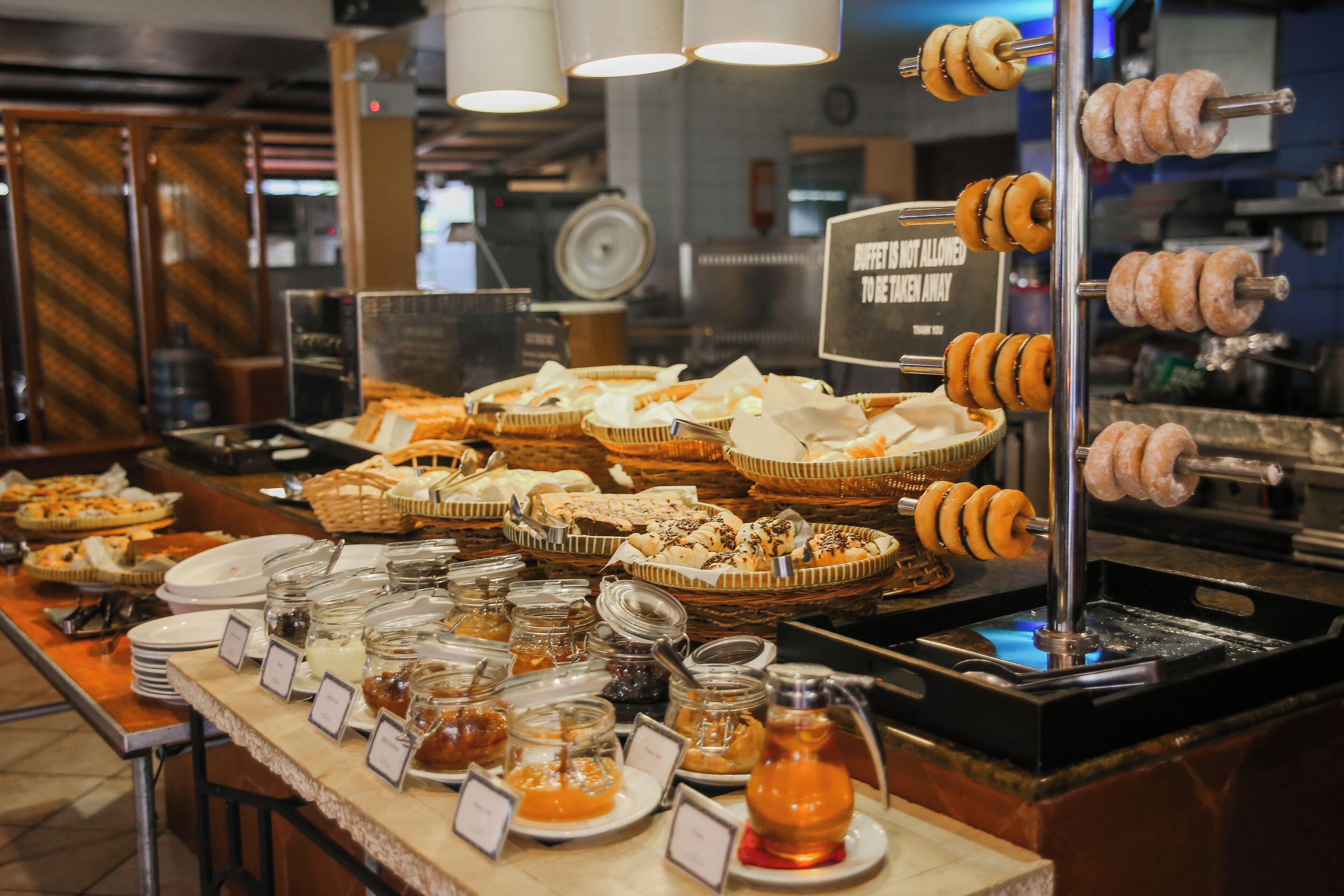 Ein Buffet mit verschiedenen Speisen und ein Schild, das darauf hinweist, dass kein Buffet-Service angeboten wird.