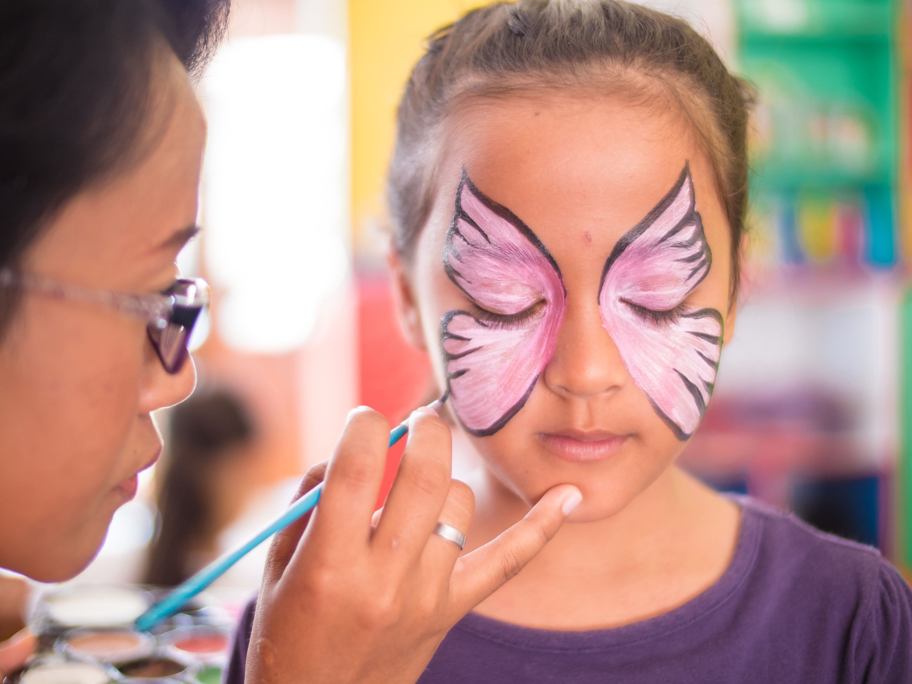 A person with butterfly wings painted on their face.
