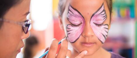 A person with butterfly wings painted on their face.