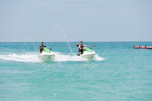 Two people jet-skiing on a calm sea with a clear sky. - Mayang Sari Beach Resort (Bintan)