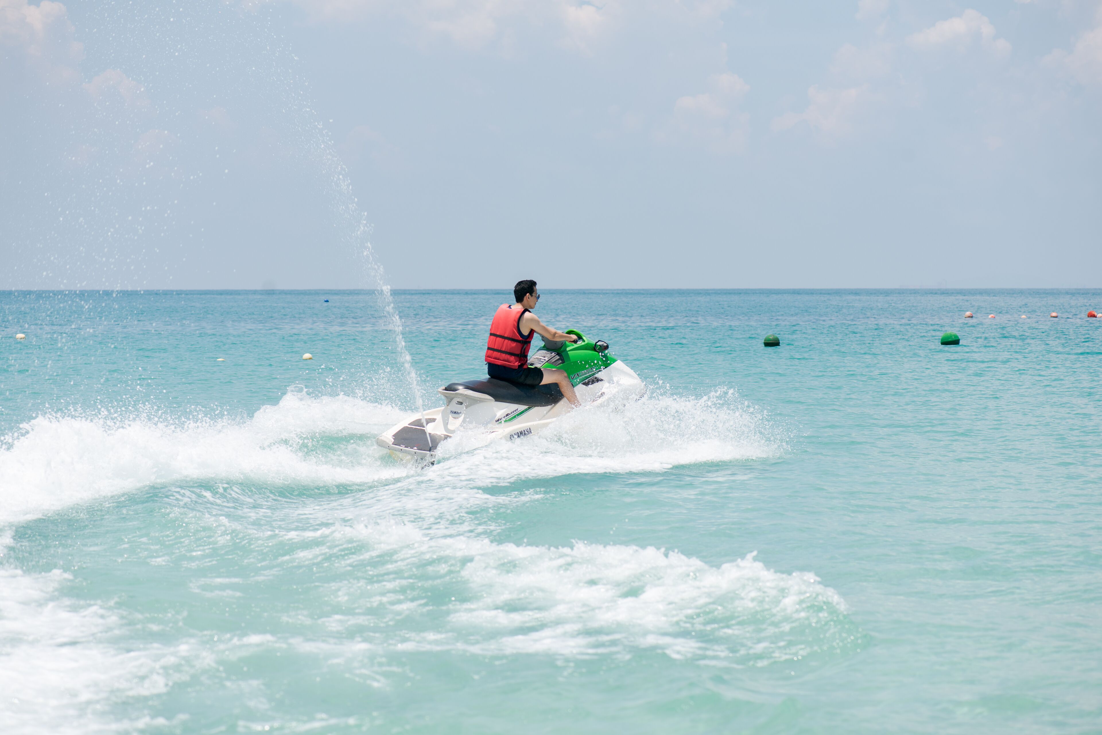 Eine Person fährt mit einem Jetski über klares Wasser.