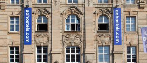 Un edificio histórico con detalles arquitectónicos ornamentados, incluyendo un arco central y columnas decorativas.