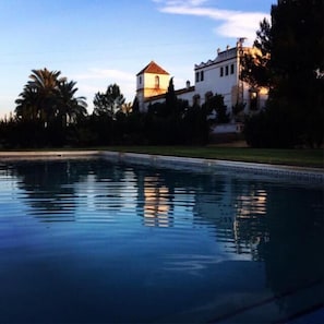 Alberca al aire libre y camastros