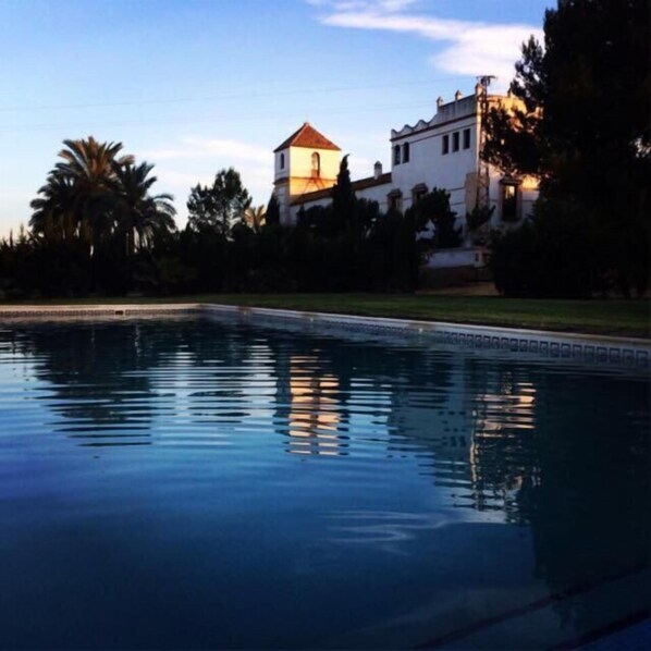 Una piscina con un edificio al fondo.