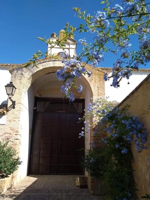 Un edificio tradicional con fachada de piedra, una entrada arqueada y una puerta de madera.