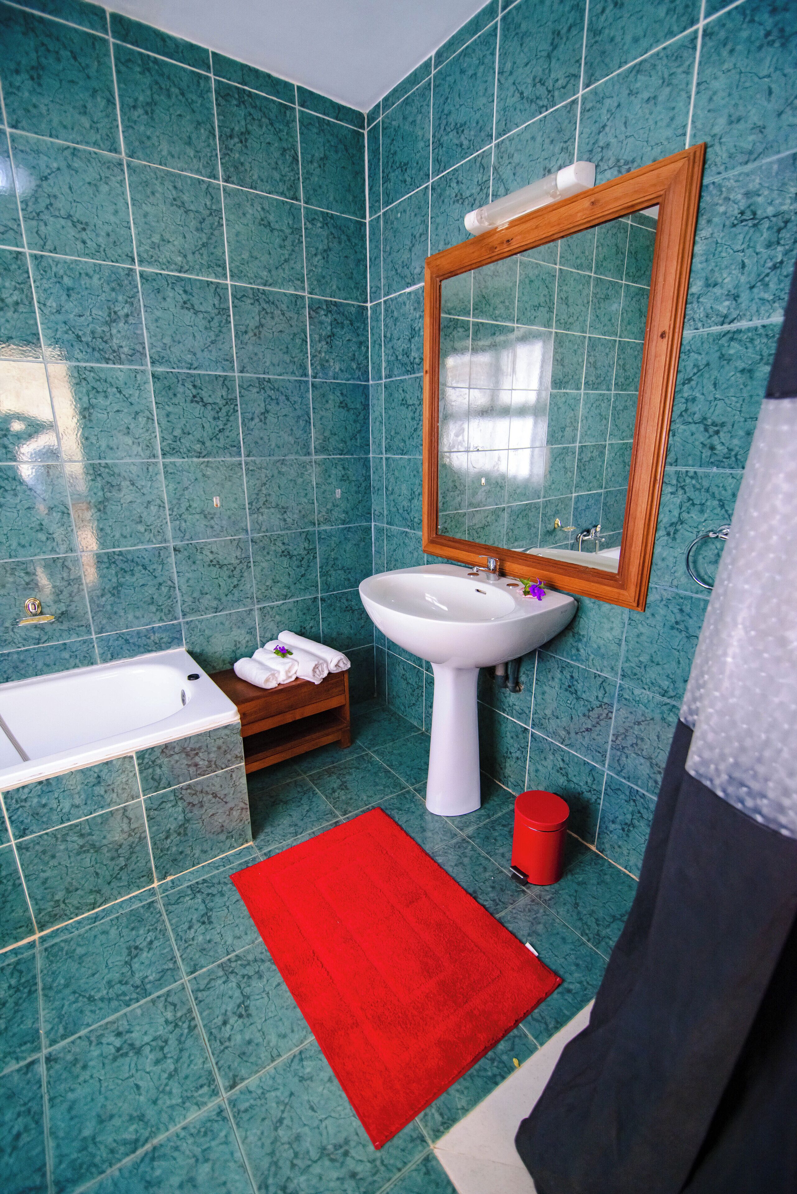 A bathroom with a sink, mirror, and bathtub.
