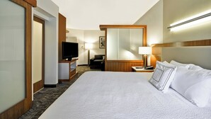 A hotel room with a large bed, a TV, a desk, and a mirror. - SpringHill Suites Tallahassee Central (Tallahassee)