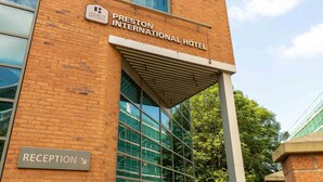 The exterior of Preston International Hotel with a reception sign and a clear view of the building's brick facade and large windows. - Legacy Preston International Hotel (Preston)