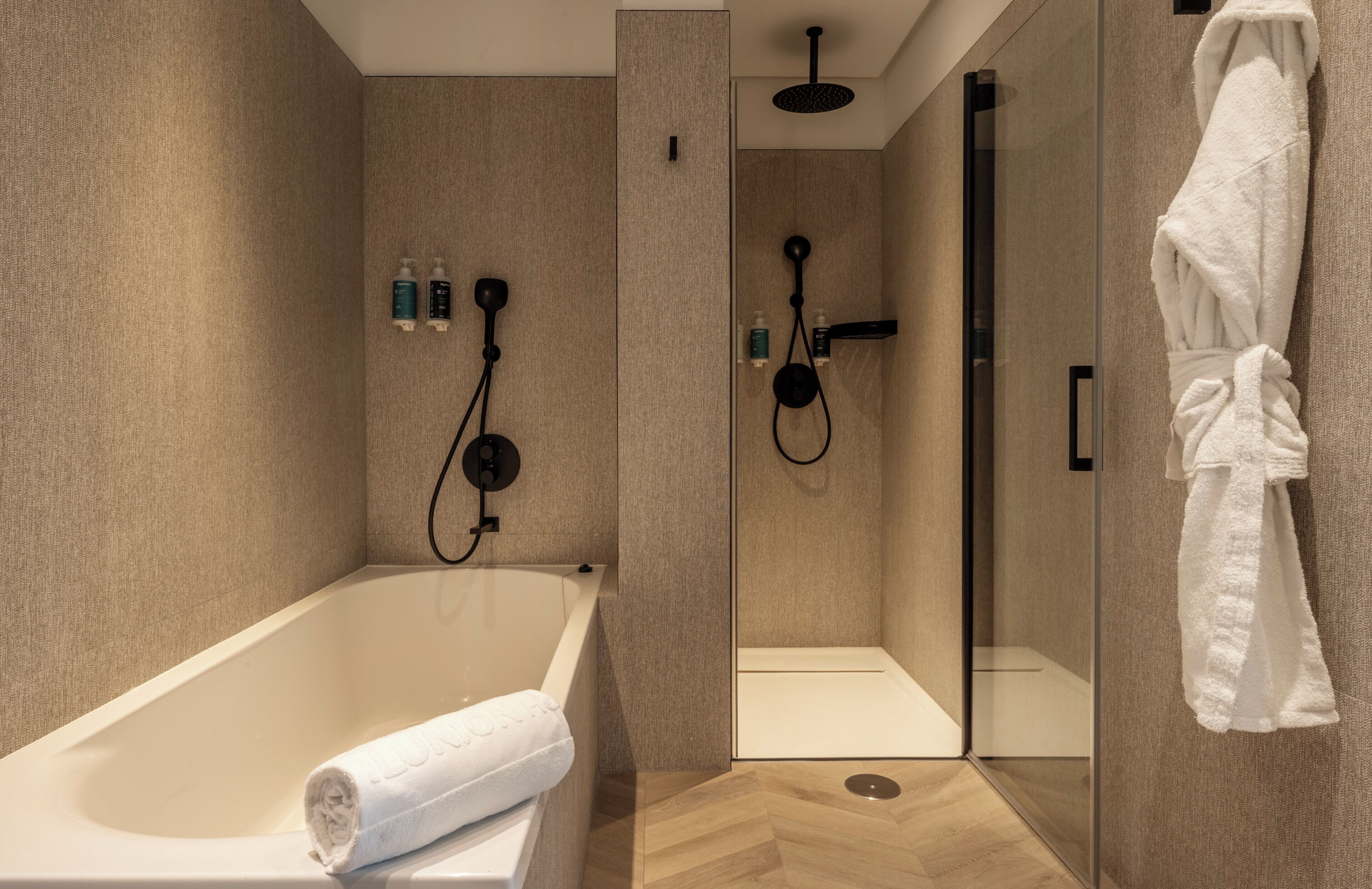 A modern bathroom with a bathtub, a walk-in shower, and a glass shower enclosure.