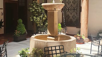 Stroll through the tranquil courtyard, surrounded by lush greenery and a soothing fountain.