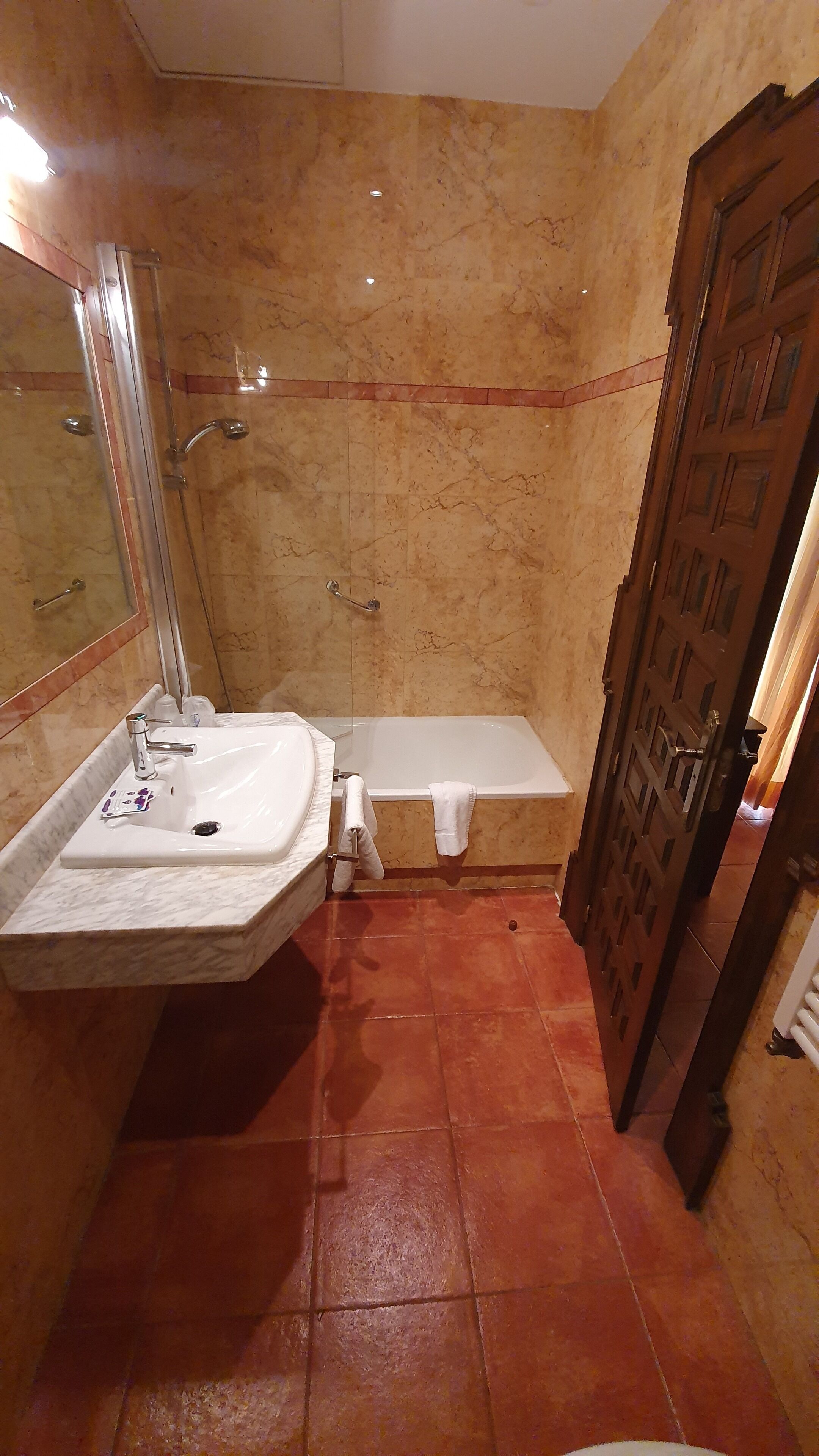 A bathroom with a sink, mirror, shower, and bathtub.