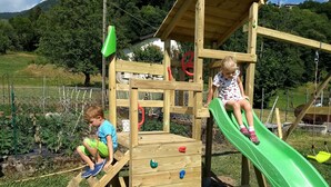 A wooden play structure with a slide and climbing elements. - Hotel Ristorante Sassi Rossi  (Crandola Valsassina)