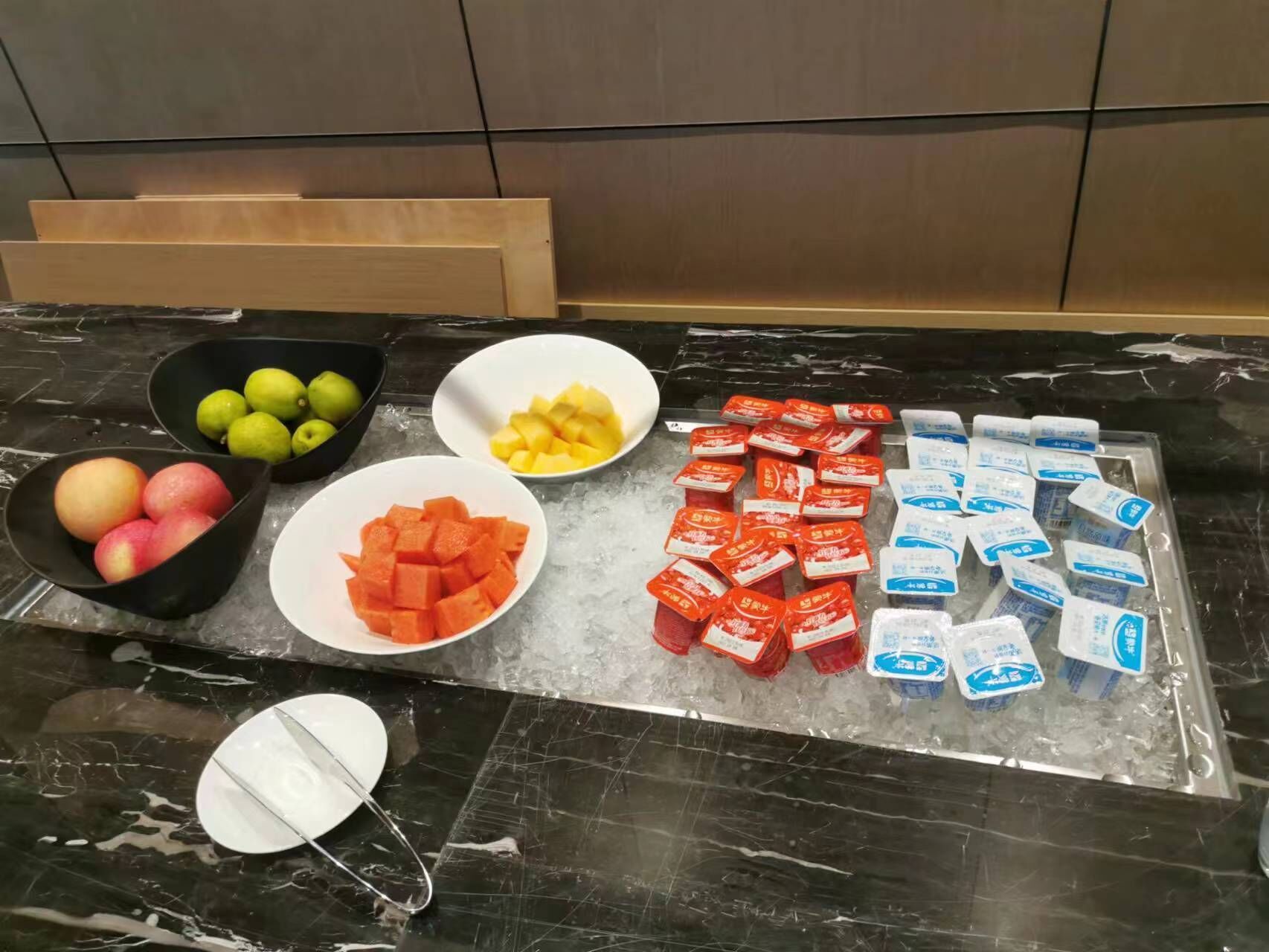 Un plan de travail en marbre avec des corbeilles de fruits et des boissons emballées.