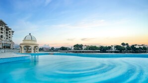 A swimming pool with a gazebo and a view of buildings in the background.