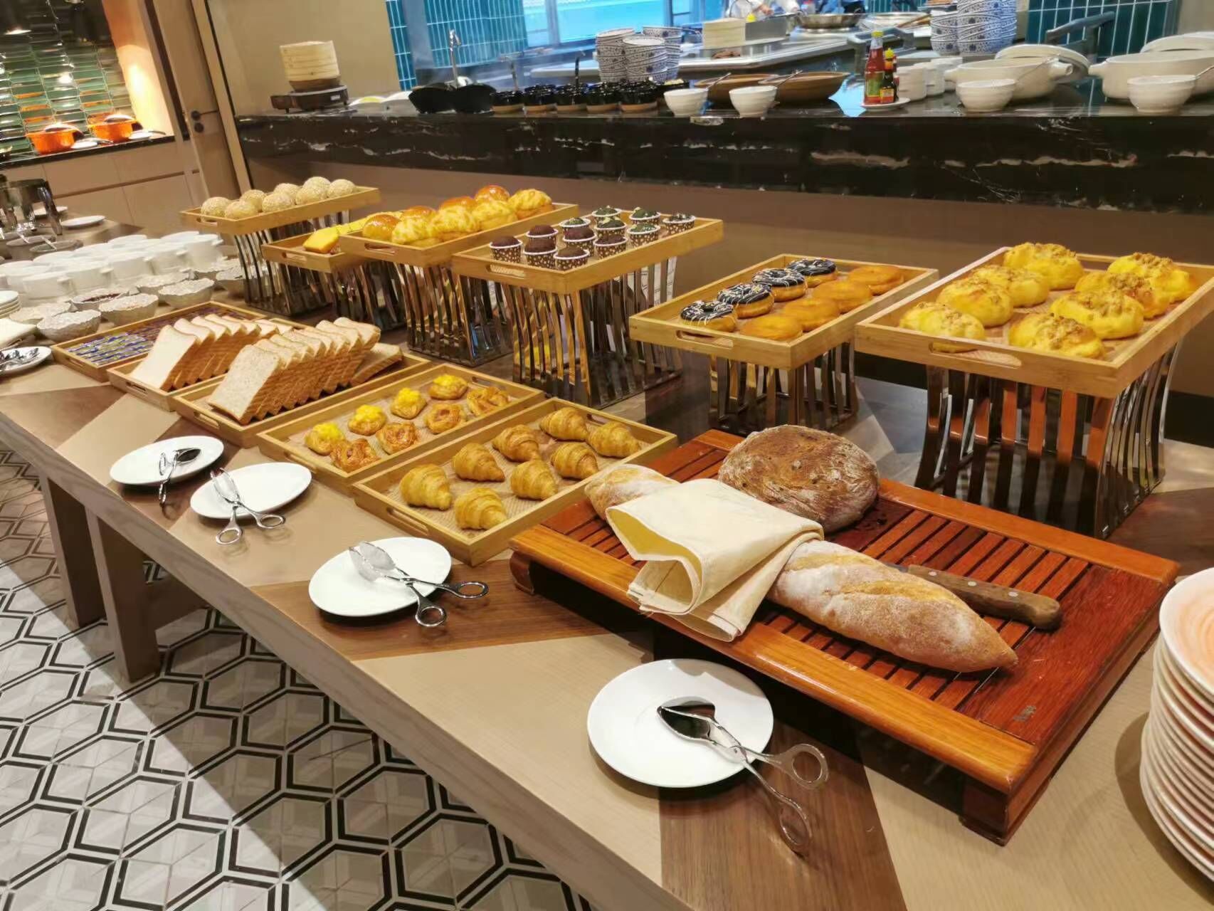 Un bufé con diferentes opciones de comida, incluyendo pan, pastelería y panes.