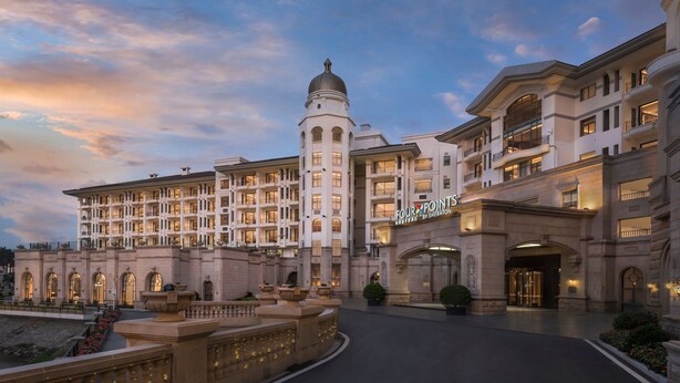 A grand hotel with multiple floors, a prominent dome, and a well-lit entrance.