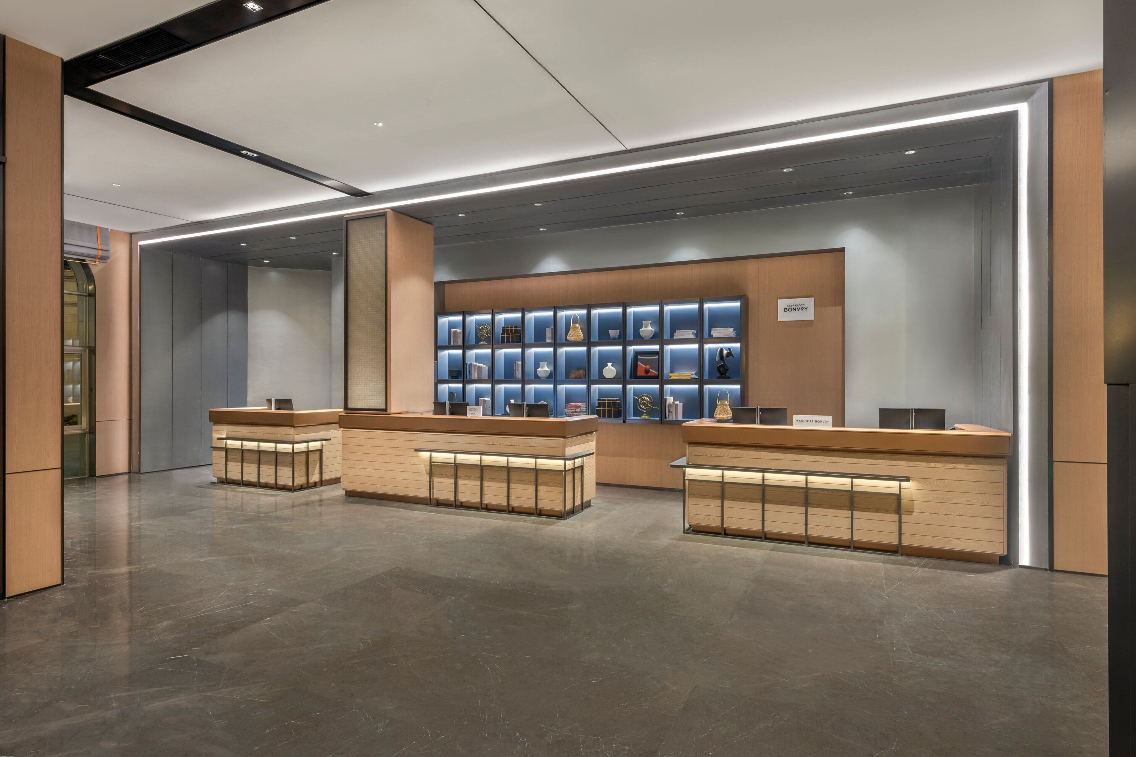 A modern reception area with a central counter and a display of various items.