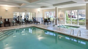 Zona de piscina con sillones de descanso y vistas al exterior.