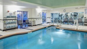 A swimming pool with a 3 FT depth marker, a changing room with chairs, and a fitness area with exercise equipment. - Fairfield Inn & Suites by Marriott Wilmington/Wrightsville Beach (Wilmington)